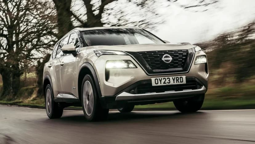 Nissan X-Trail четвёртого поколения в серебристом цвете, вид три четверти на горной дороге