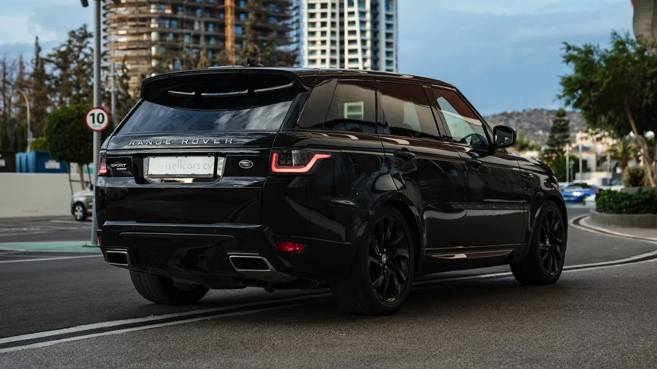 Rear three-quarter view against Limassol high-rises. Car 95