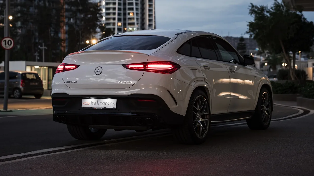 Rear three-quarter view at dusk against the city. Car 96