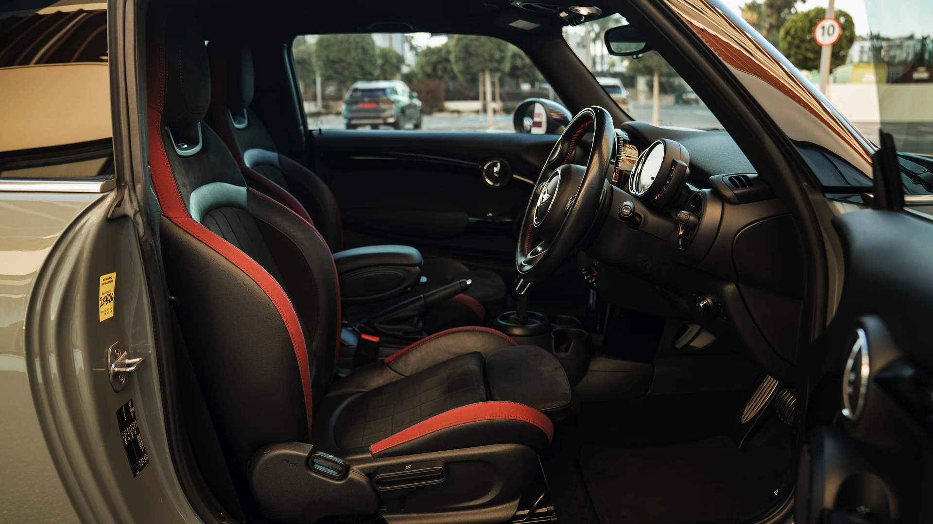 Mini John Cooper Works interior through open door, sports seats and red trim. Car 78