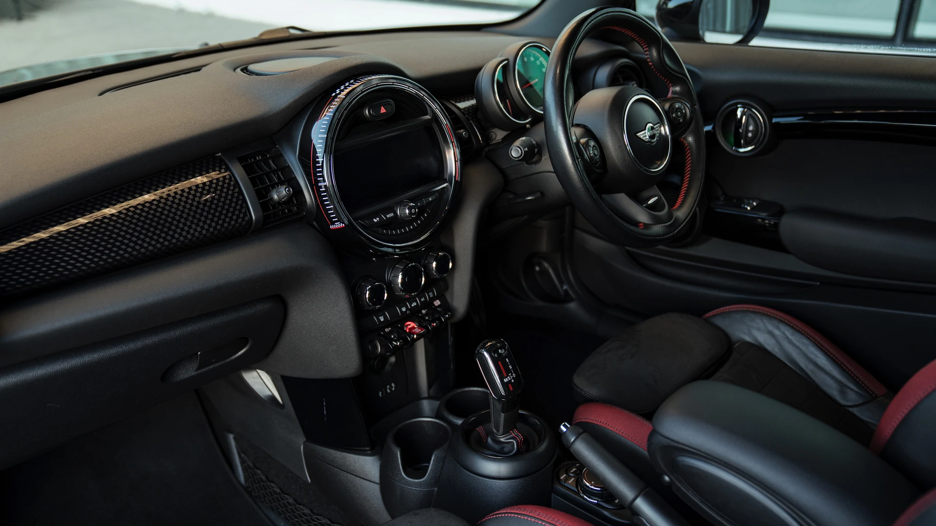 Mini John Cooper Works dashboard and driver display, red contrast stitching. Car 78