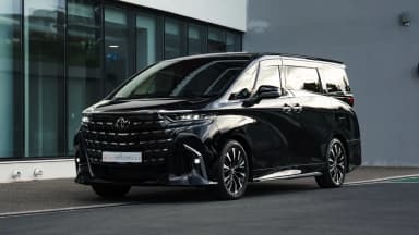 Black 2025 Toyota Alphard Executive Lounge in Cyprus, front three-quarter view outside the showroom. Car 97