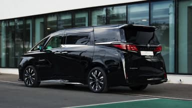 Rear three-quarter view by the glass showroom facade. Car 97