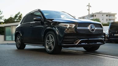 Front three-quarter exterior view against an urban backdrop. Car 86
