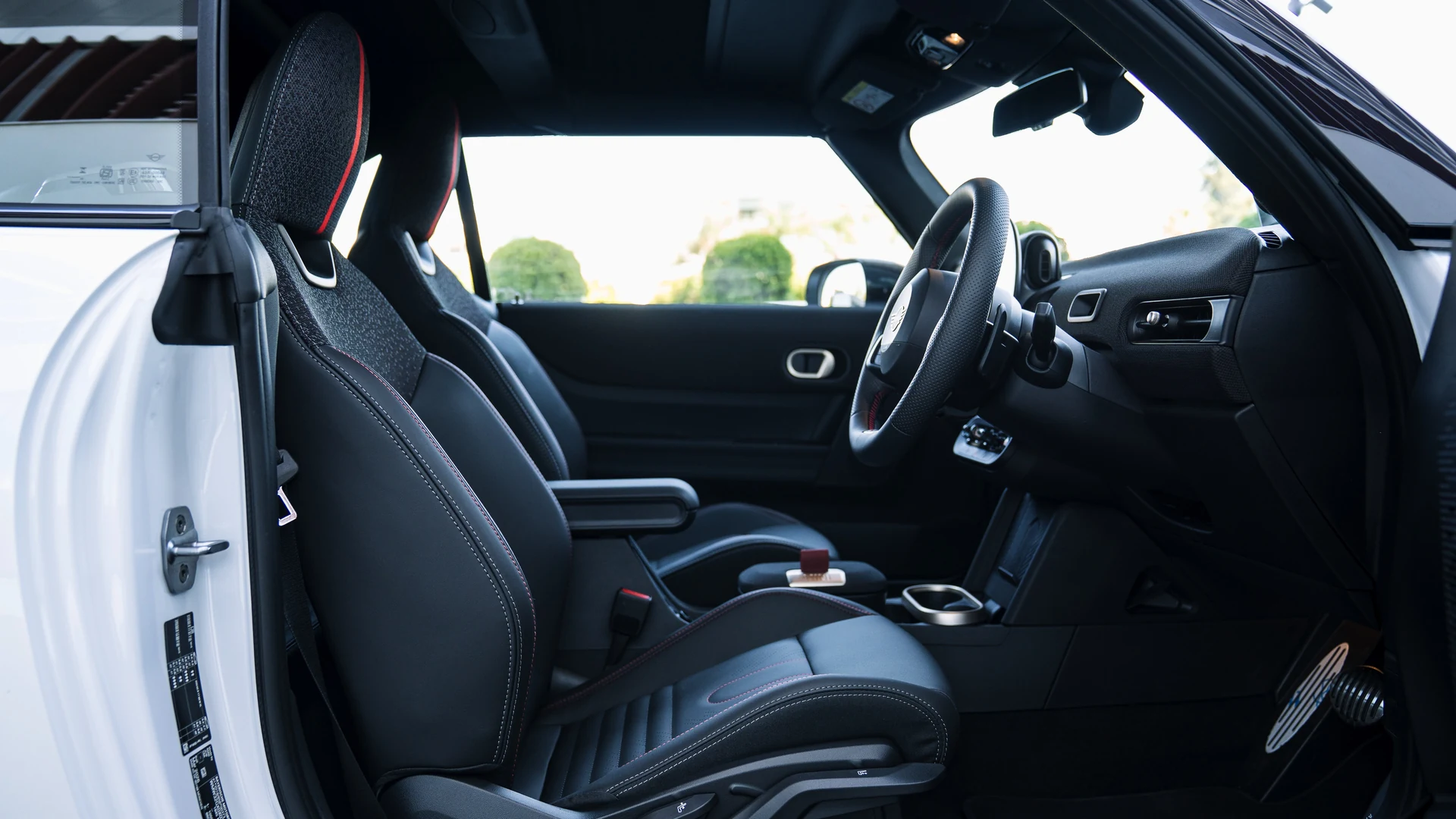 Interior, roof up, JCW sport seats in black with red stitching. Car 81