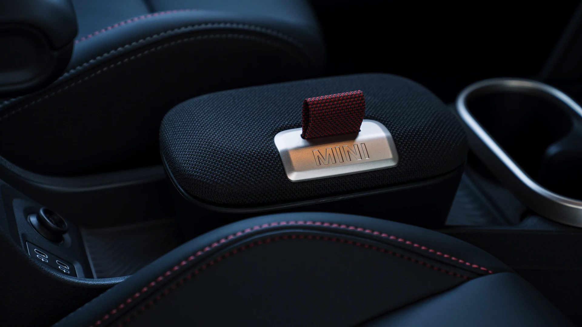 Centre armrest detail, MINI branded storage compartment with red pull tab. Car 81