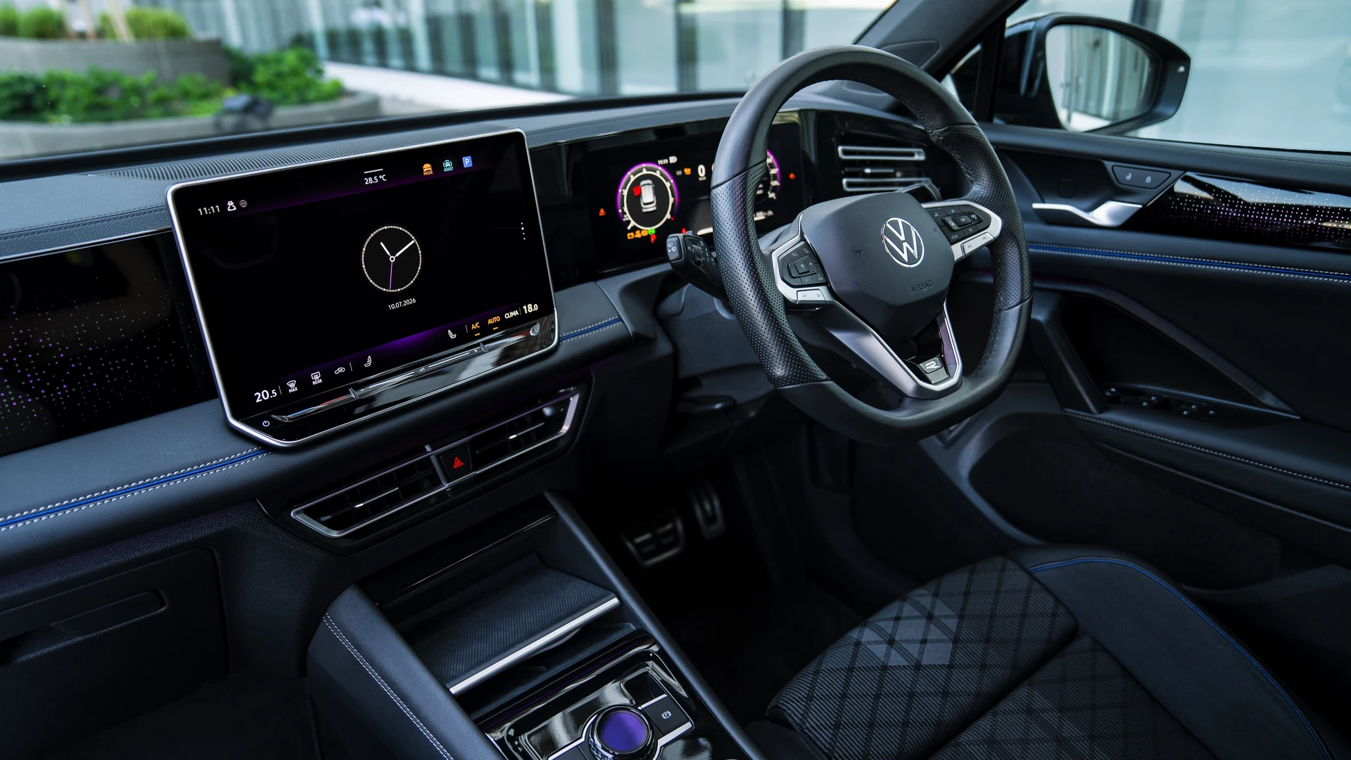 Interior from passenger side, wide infotainment display and ambient lighting. Car 82