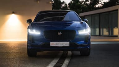 Front view with headlamps illuminated against the low evening sun. Car 88