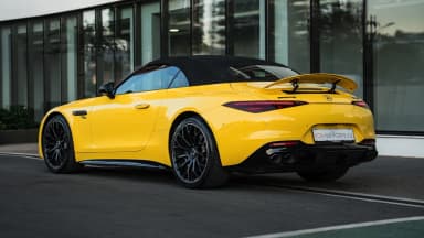 Rear three-quarter view with the spoiler raised and soft top closed. Car 91