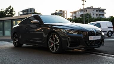 Front three-quarter view on a city street at dusk. Car 90