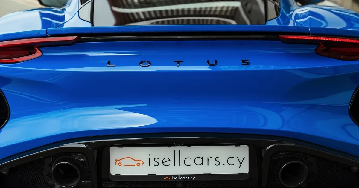 Rear of a blue Lotus Emira with no number plate yet — an isellcars.cy holder before first registration in Cyprus